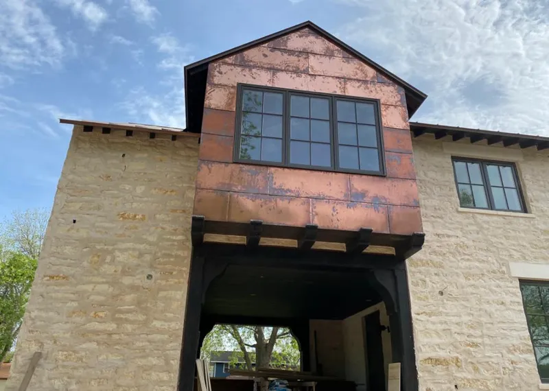 Copper metal panel facade on a stone building for Roof Repair in Centerville